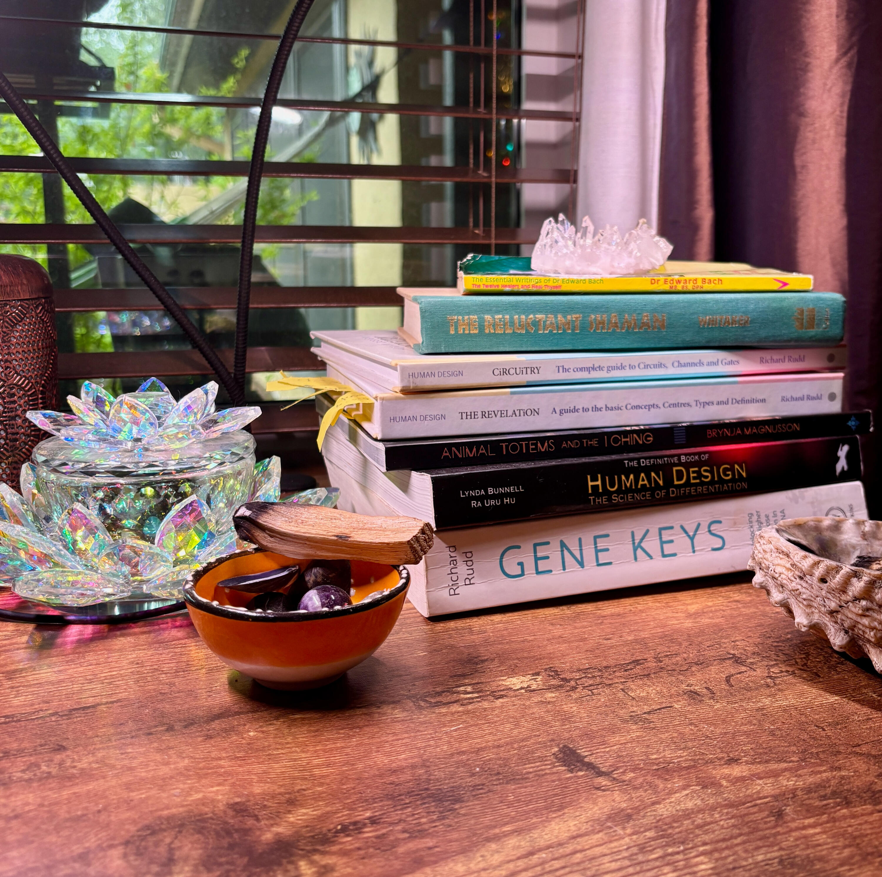 Krystal Linnea - Human Design Self - SelfAwakening Blog on Substack Krystal Linnea's desk, with books including The Gene Keys, The Definitive Book of Human Design, The Revelation, Circuitry, The Reluctant Shaman, and The Essential Writings of Dr. Edward Bach + Heal Thyself - along with crystals, palo santo, and quartz.